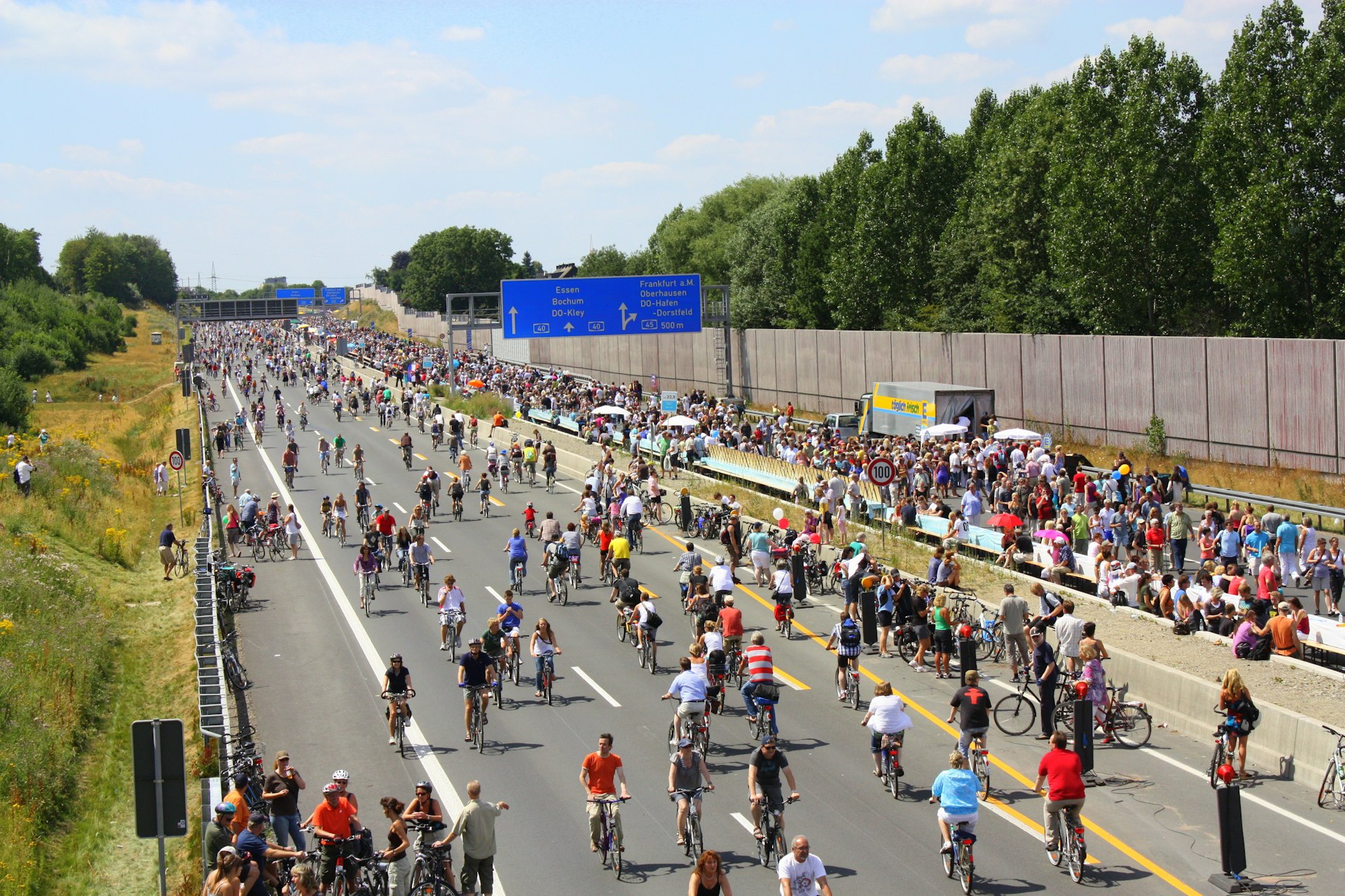 A large group of people riding bikes down a street